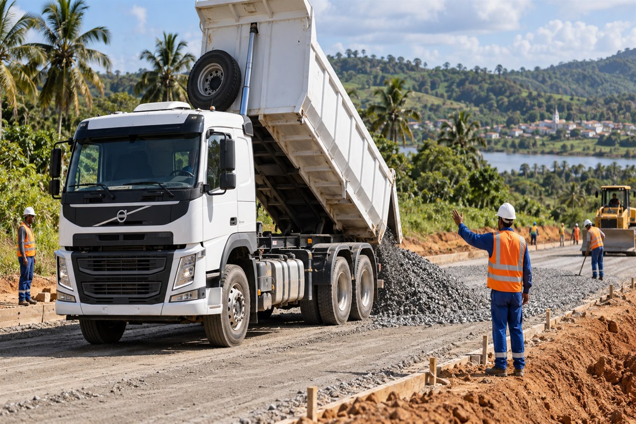Caminhão caçamba Volvo branco entregando agregado em obra